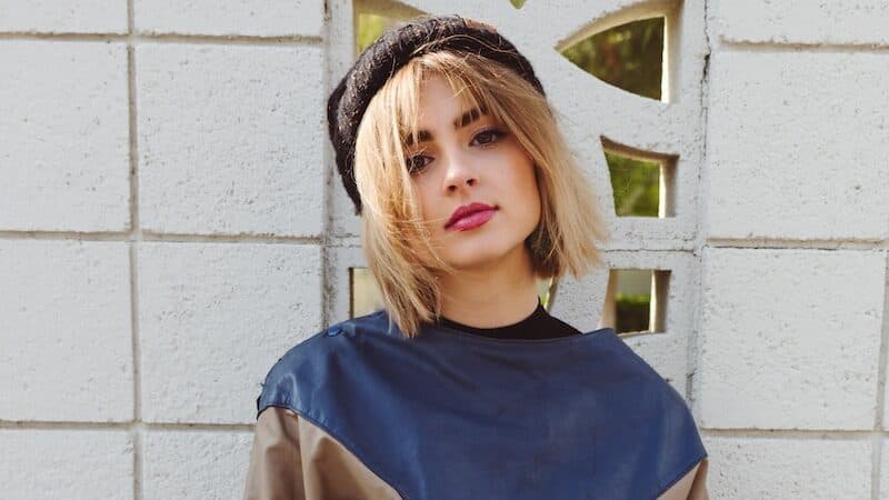 a woman standing in front of a white wall