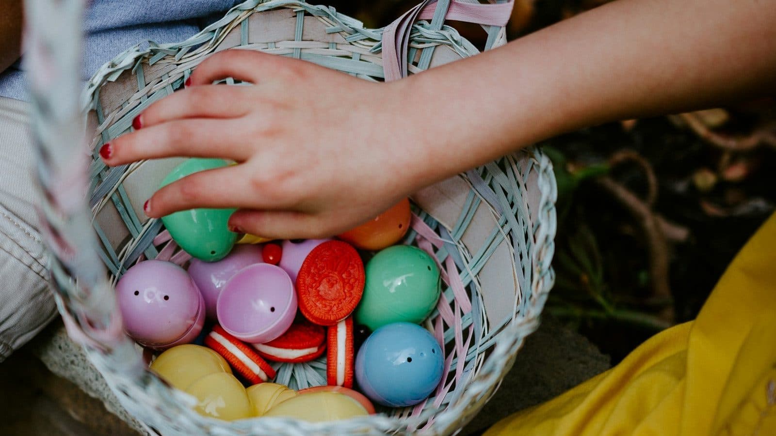 person holding a basket of easter eggs